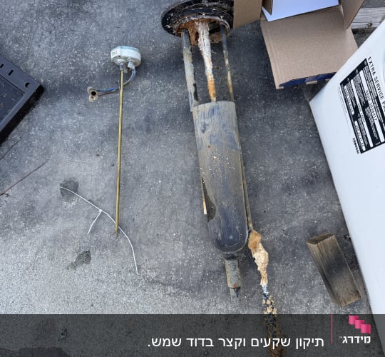 חלקי ציוד חשמלי ישנים ומחלידים על הרצפה